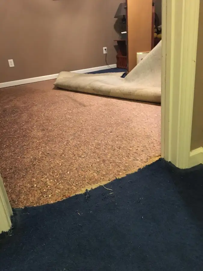 Carpet pad removal revealing water damage during Water Mitigation Services in Delanco